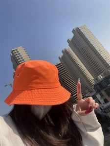 Close-up of bright orange cotton bucket hat with sun protection for street style outfits
