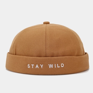 Detail of Stay Wild embroidery on brown canvas docker cap showing fabric texture