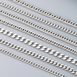 Polished silver stainless steel Cuban link chains in various widths on blue background