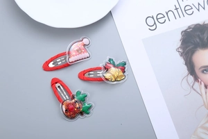 Detail view of 3 Christmas hair clips with glitter sequins and festive cartoon patterns