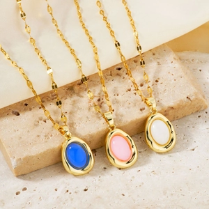 Elegant egg-shaped pendant necklaces in blue, pink, and white on gold chains over stone