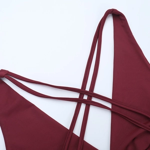 Detail shot of criss-cross back straps on a deep red halter dress with slim fit