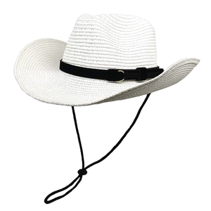 Detail of white woven straw cowboy hat featuring black suede band and gold buckle