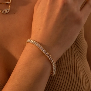 Macro view of 18K gold plated tennis bracelet with square zircons on female wrist