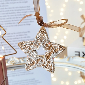 Brown resin gingerbread star ornament with white floral detail for Christmas tree decor