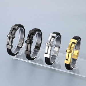 Detail view of woven leather bracelets with cross buckle in silver, gold, and black colors
