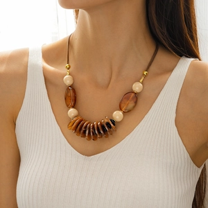 Close-up of a double-layer acrylic oval pendant necklace with bohemian resin beads