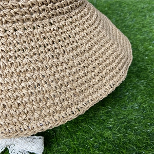 Close-up of hand-woven straw hat texture with elegant white lace bow detail