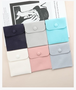 Detail showing six colorful velvet jewelry pouches with snap buttons in soft suede
