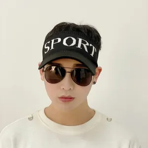 Gros plan sur une visière en tricot noir avec broderie SPORT et lunettes de soleil aviateur
