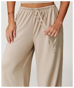 Detail of high-waist drawstring waistband on beige wide-leg knit trousers