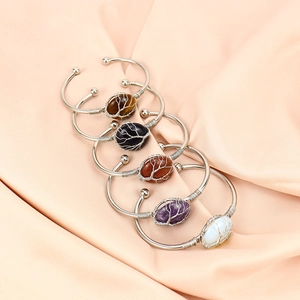 Detailed wire-wrapped crystal bracelets with tree of life design on silk background