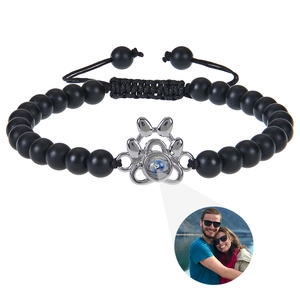 Detail of dog paw projection bracelet showing custom photo feature on black matte beads