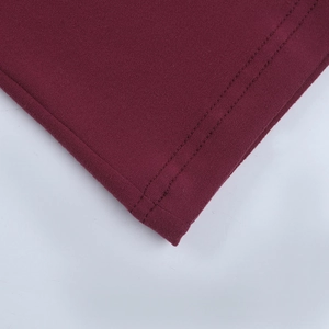 Close-up of wine red lace dress hem featuring precise double-stitch sewing and knit texture
