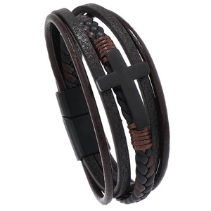 Dettaglio del bracciale in pelle multistrato con croce in metallo nero e chiusura magnetica