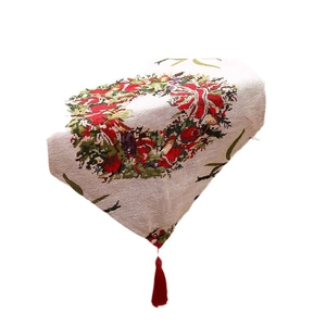 Christmas table runner with festive floral wreath patterns and red tassel decorations