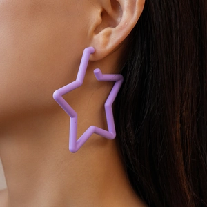 Gros plan d'une grande boucle d'oreille en acrylique violette en forme d'étoile