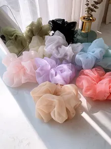 Macro detail of large organza hair scrunchies with pleated texture and soft satin sheen