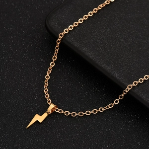 Golden lightning bolt pendant necklace with stainless steel chain on black background