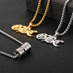 Detailed close-up of dumbbell and Babe pendants on box chains in silver and gold steel