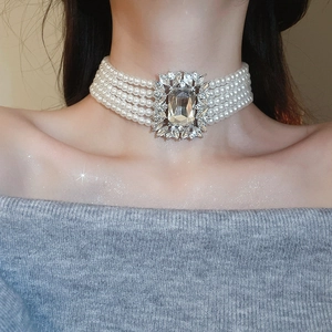Close-up of layered pearl necklace with square rhinestone centerpiece on female model