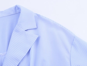 Close-up of light blue striped shirt collar and shoulder tailoring with neat stitching