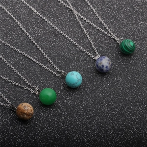 Minimalist round stone pendant necklaces with silver chains on dark background