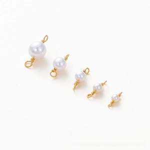Detailed view of white pearls with 18K gold-plated wire wrapping for DIY jewelry