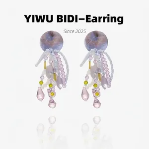 Detail view of jellyfish style earrings with purple beads and crystal tassel drops