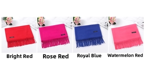 Multiple solid color cashmere-like scarves featuring elegant fringe in red, pink, and blue