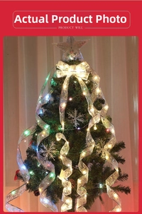 Close-up of silver Christmas ribbon with warm LED lights and snowflake ornaments