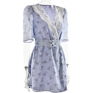 Détail de robe fleurie bleue avec décolleté en dentelle blanche et boutons en perles
