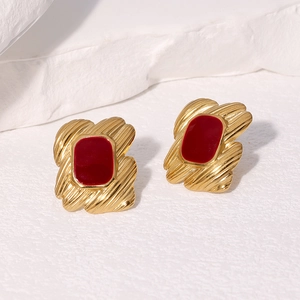 Detailed shot of 18k gold plated earrings with red enamel inlay and wavy texture