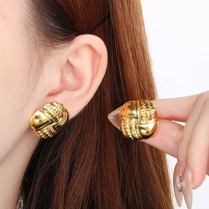 Macro shot of gold stainless steel earrings with vintage embossed rippled texture
