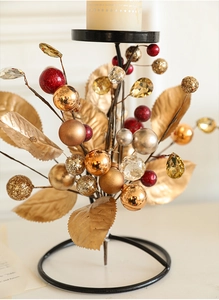 Detail of Christmas iron candlestick with golden leaves, colorful baubles and crystal accents