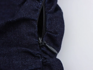 Gros plan sur le tissu denim bleu foncé avec fermeture éclair et détails de couture précis