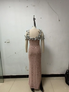 Detail of rose gold evening dress with heavy beadwork and silver leaf appliques