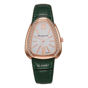 Close-up of ladies fashion watch with emerald green leather strap and diamond-set bezel