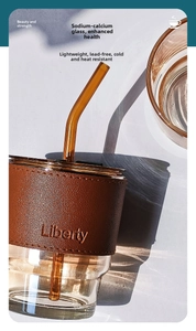 Detail of amber glass straw and leather sleeve on bamboo-style coffee tumbler