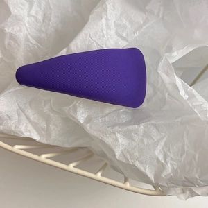 Close-up of a purple textured sponge hair clip on a minimalist white backdrop