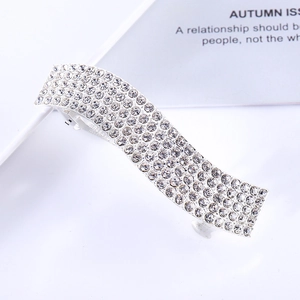 Close-up of a silver wavy hair clip with sparkling rhinestones on a white background