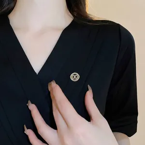 Luxurious gold-plated circular brooch with zircon flower and bow design on a blazer