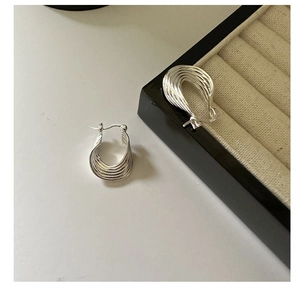Detail van meerlagige gebogen oorbellen van S925 sterling zilver met gepolijste glans
