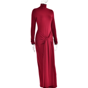 Détail d'une robe longue rouge ajustée présentant un nœud à la taille et des plis élégants