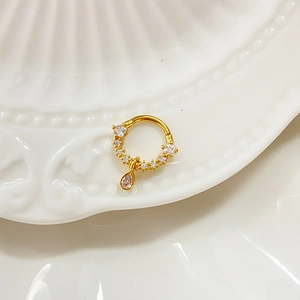 Golden drop nose ring with cubic zirconia inlay on a polished circular band