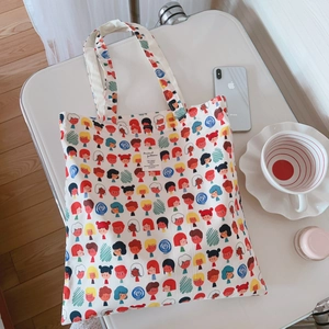 Gros plan détaillé sur l'imprimé cartoon coloré et l'étiquette tissée du sac fourre-tout