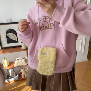 Close-up of plush yellow mobile phone bag with purple strap and cute letter patch