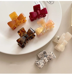 Flat lay of multiple acetate bow hair claws in tortoiseshell and marble patterns