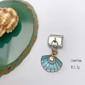 Close-up of light blue enamel charm with shell and agate on white background