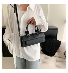 Details der minimalistischen schwarzen Kunstleder-Handtasche mit silbernen Beschlägen